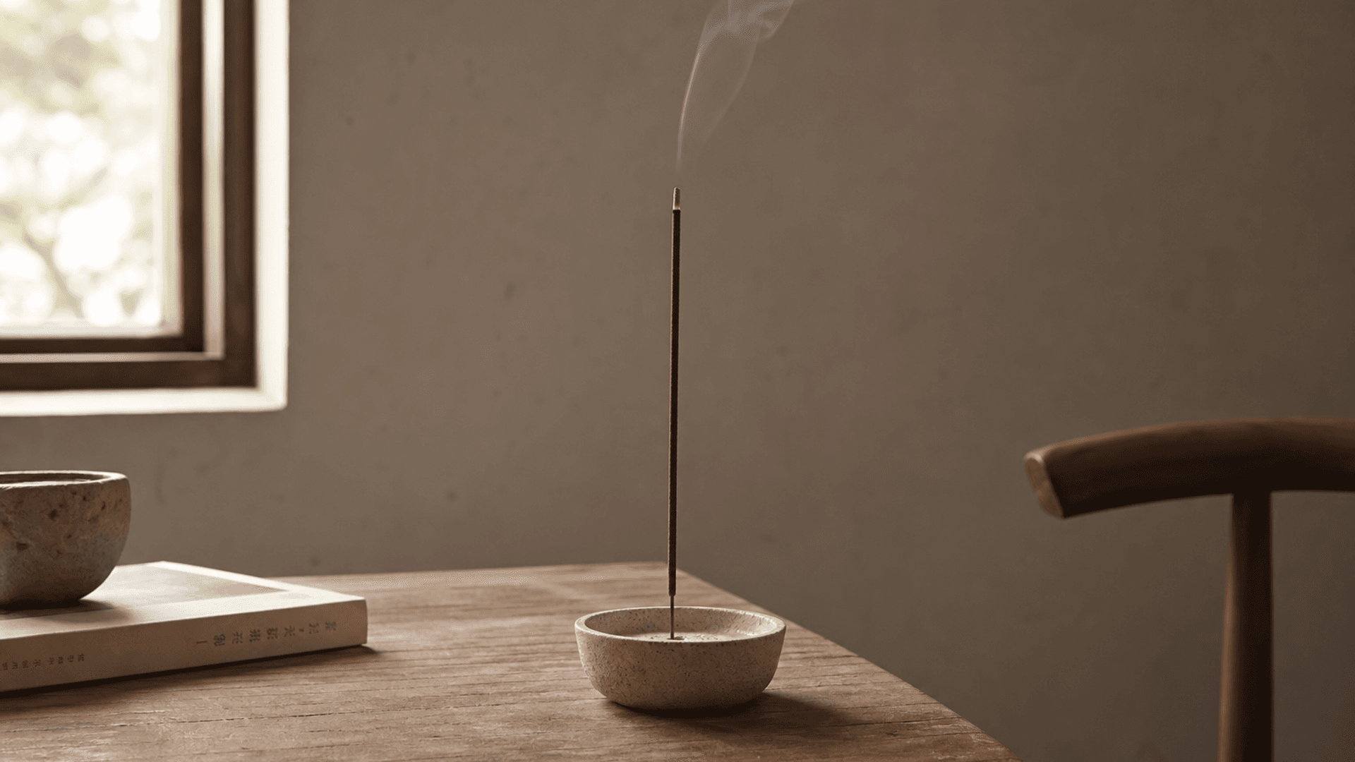 Writing desk with tea and incense in soft daylight